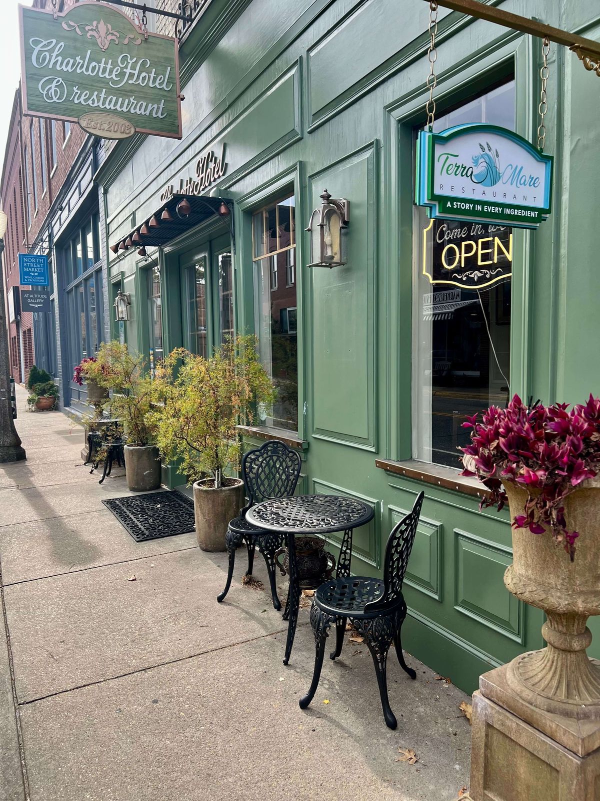 The Charlotte's sidewalk and green storefront
